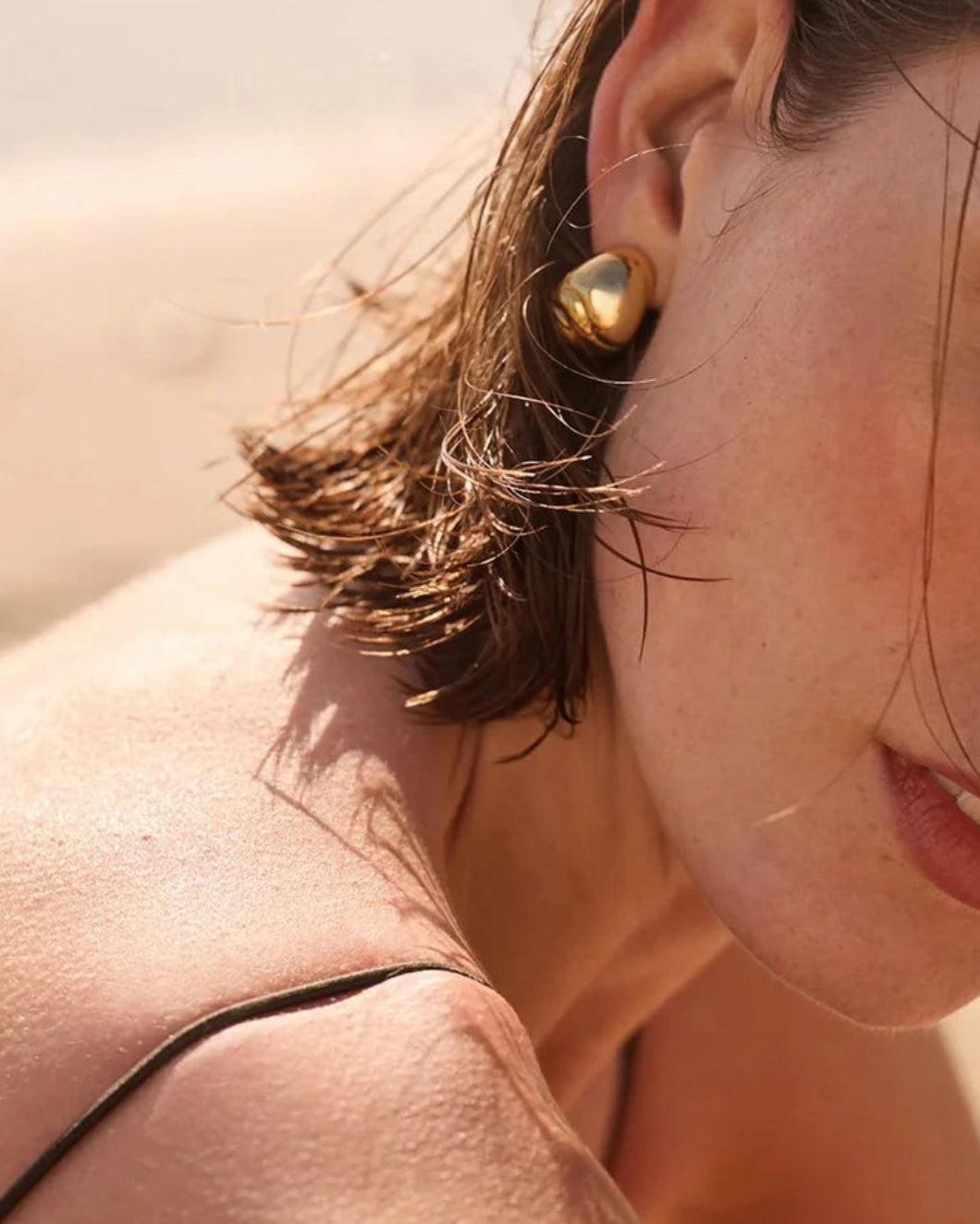 JENNY BIRD nelle hoop earings gold on figure side