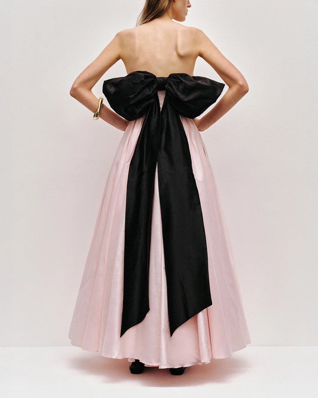 Thea strapless pink tint gown with large black bow at the back by aje shown from the back view