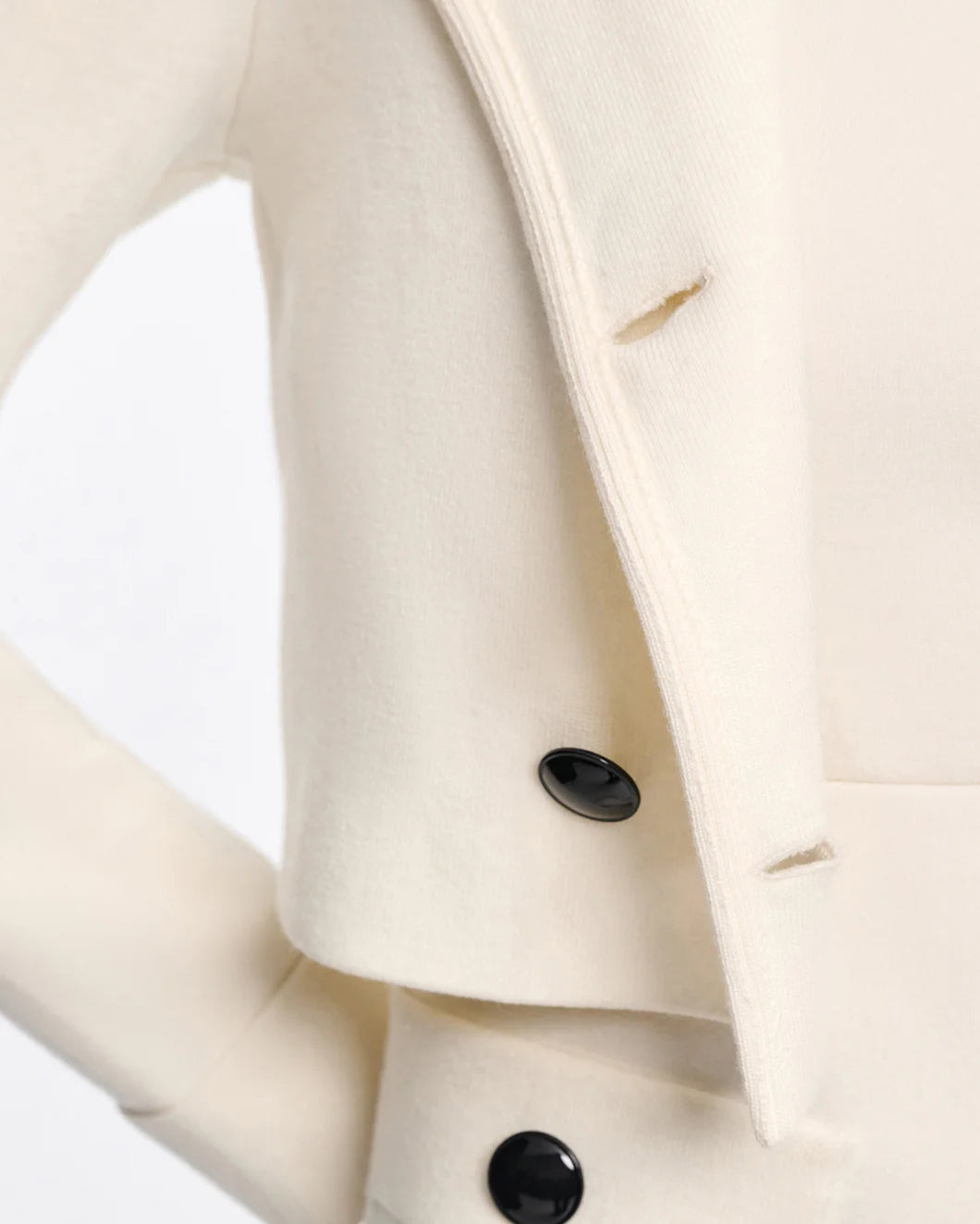 White cropped wool jacket with black buttons by Dorothee Schumacher, styled with turned cuffs and retro-modern silhouette