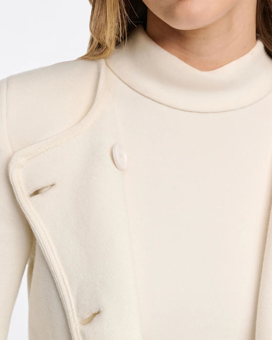 White cropped wool jacket with black buttons by Dorothee Schumacher, styled with turned cuffs and retro-modern silhouette