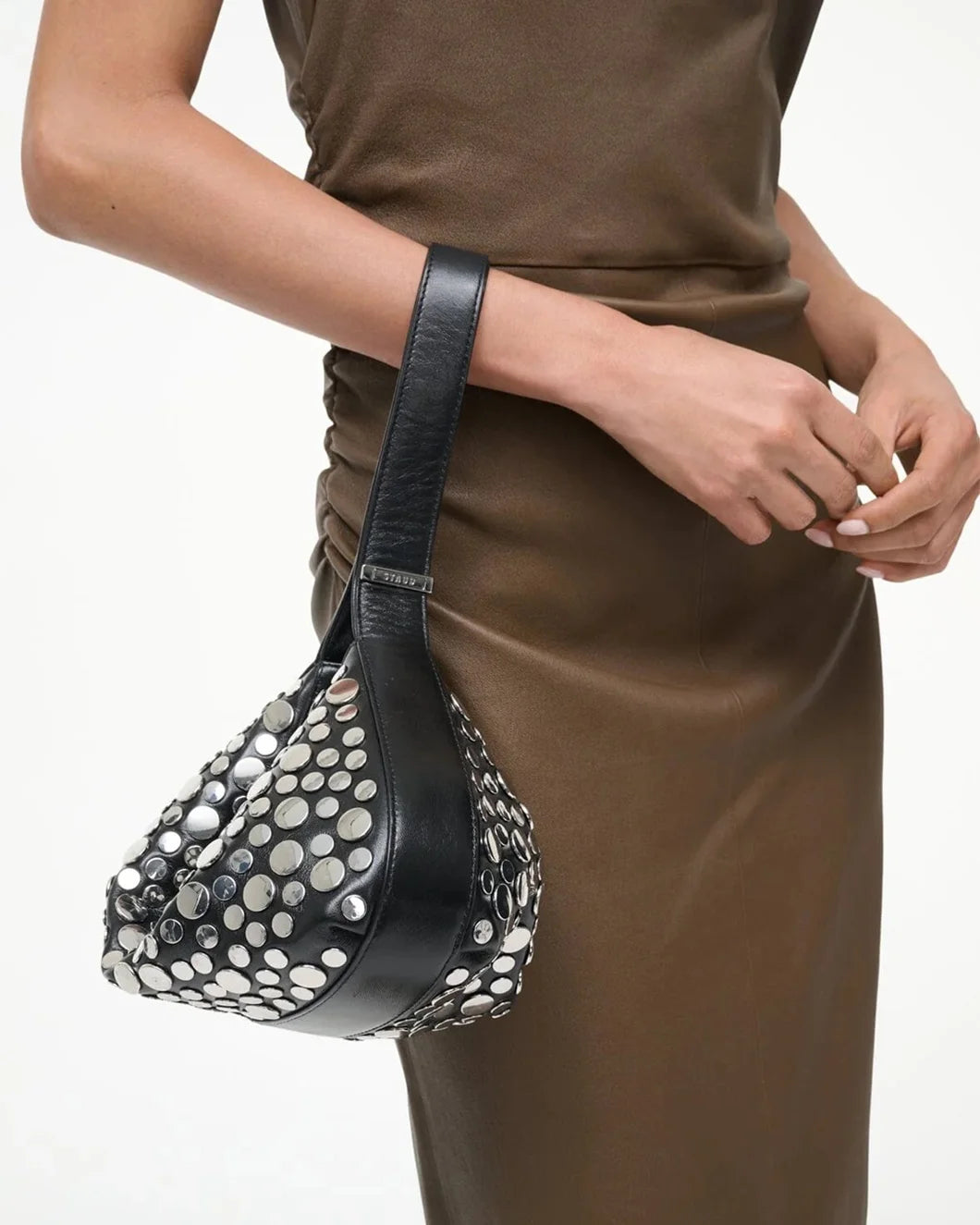 staud demy shoulder bag in black with silver rivets as wrislet on figure