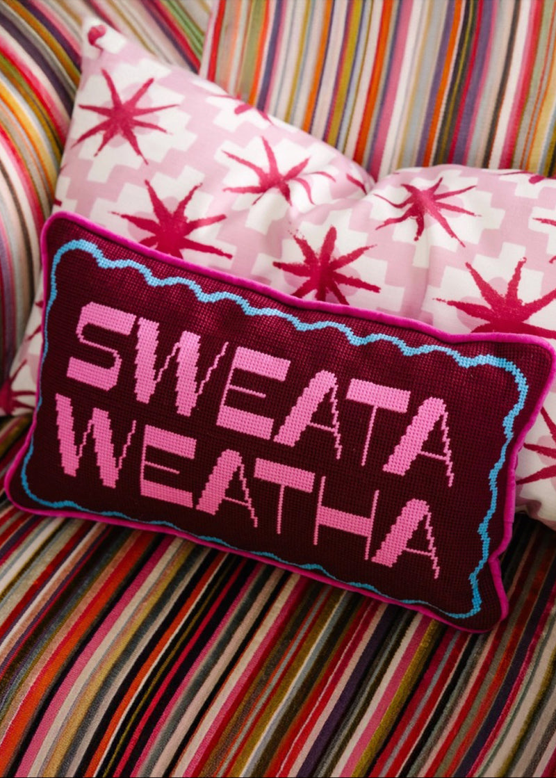 Decorative Frubish Studio pillow with 'SWEATA WEATHA' text on a striped background