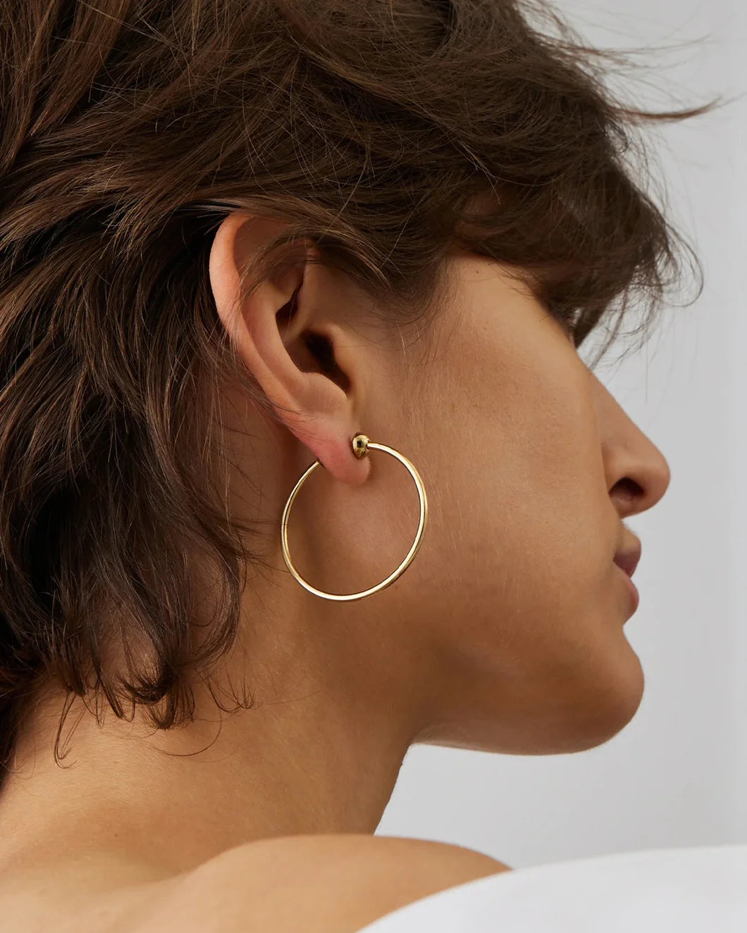 JENNY BIRD icon hoops small gold on figure front