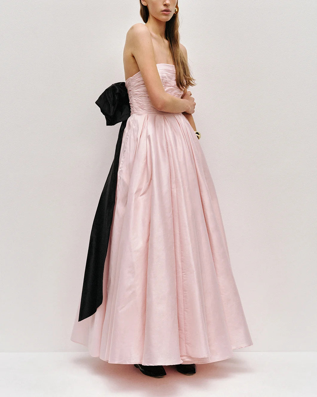 Thea strapless pink tint gown with large black bow at the back  by aje shown from the side view