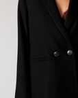A close up detail of a black blazer with two buttons on it.